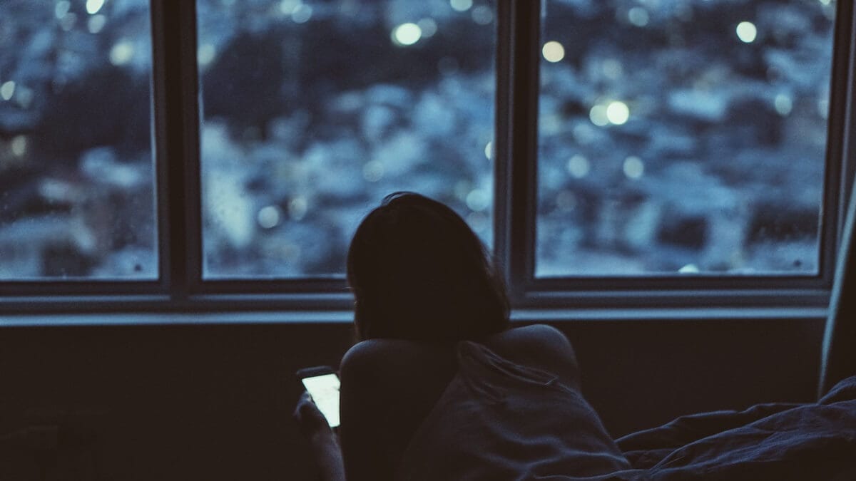 Donna con dispositivi elettronici, smartphone, di notte